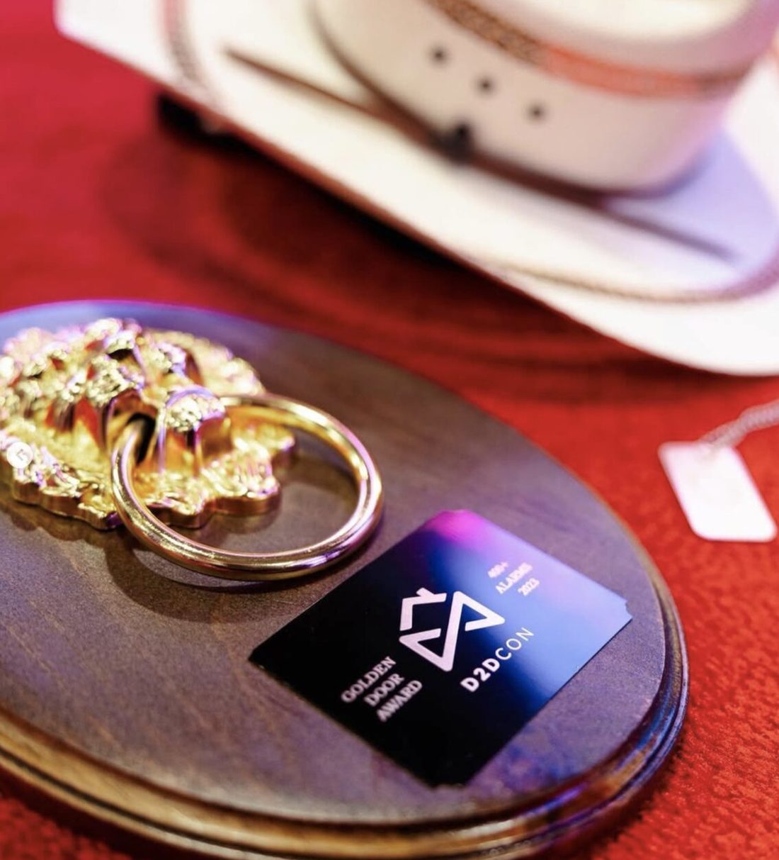 Valor's Golden Door Award trophy and D2DCon 2023 credential on a table